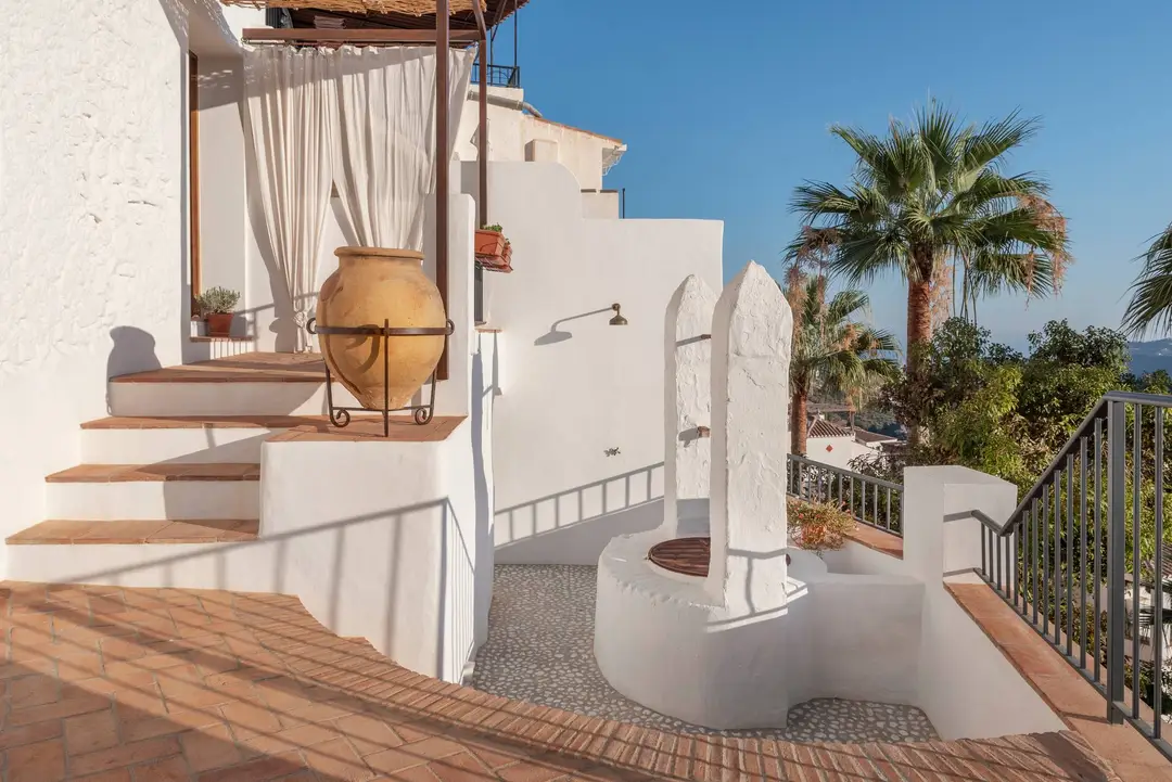 Terraza privada con paredes blancas y palmeras en AMARA Lounis, Frigiliana