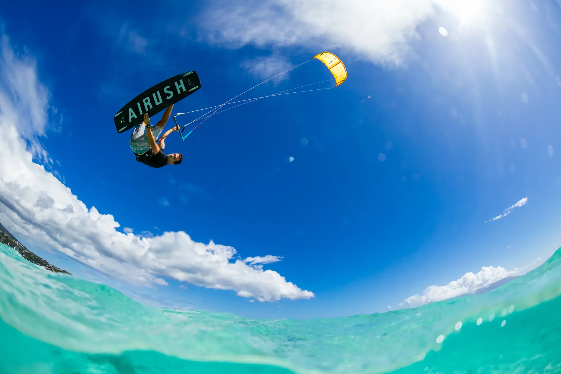 Kitesurfista en el aire bajo un cielo azul frente a Tarifa