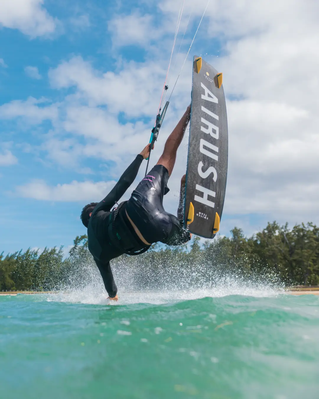 Un kitesurfista ejecutando un truco strapless sobre el agua