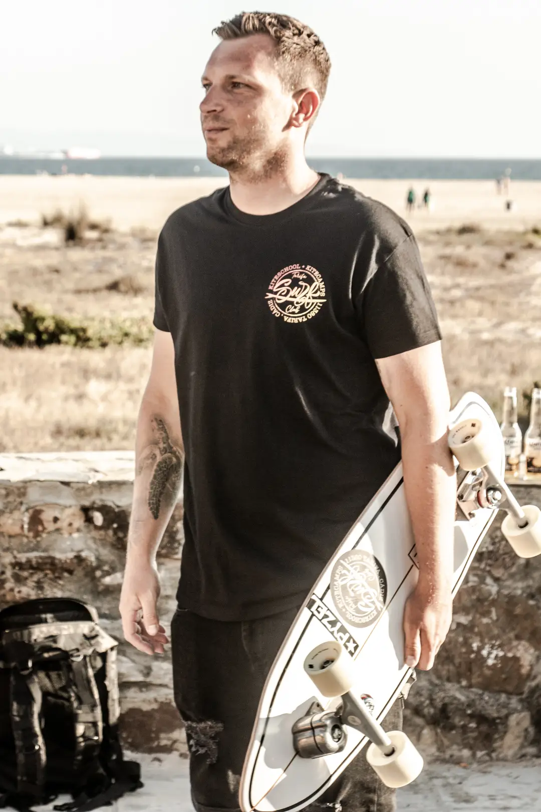 Un miembro del Tarifa Surf Club con un longboard en la playa de Tarifa