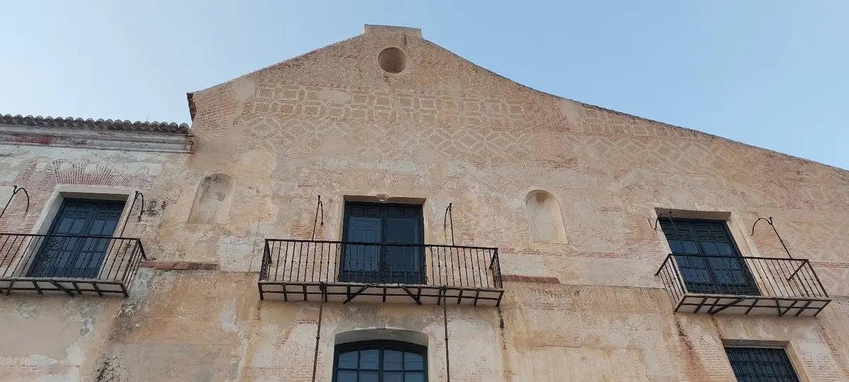 La fachada de esgrafiados de El Ingenio con bandas geométricas y balcones
