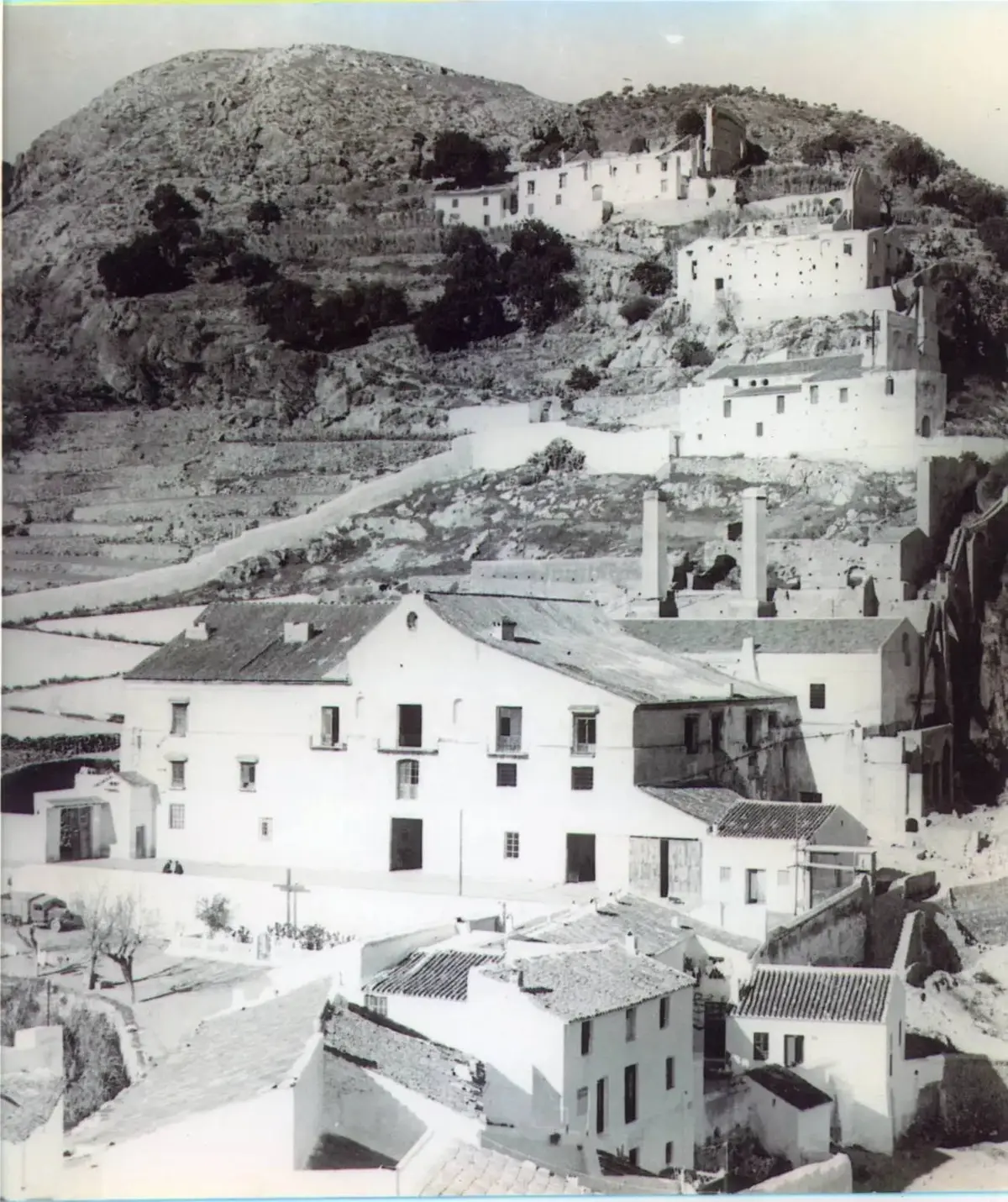 Fotografía histórica de Frigiliana bajo el Peñón, con las chimeneas del antiguo ingenio