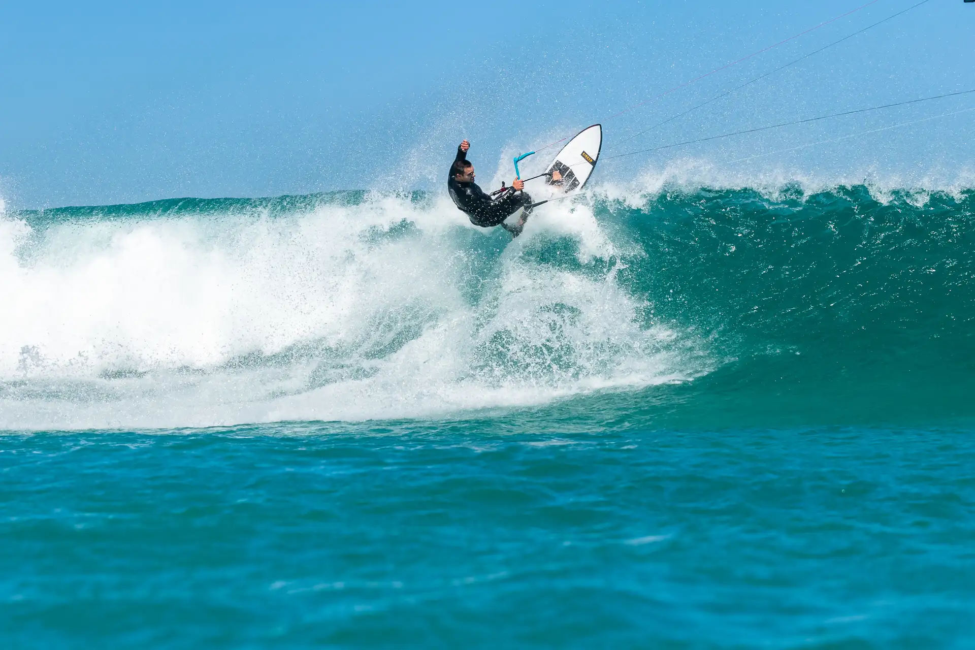 Un kitesurfista trazando un giro en la cresta de una ola frente a Tarifa