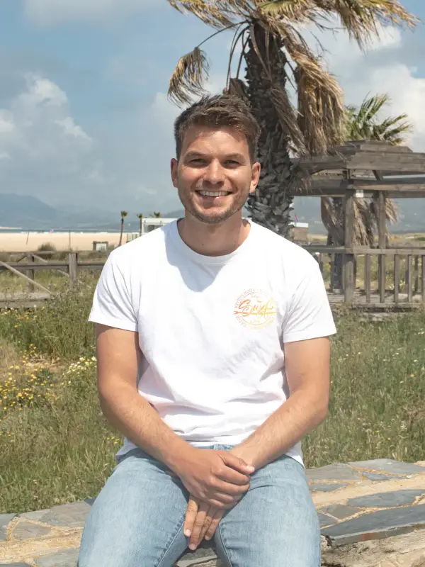Lukas von Work Surf Balance, im weißen Shirt am Strand von Tarifa