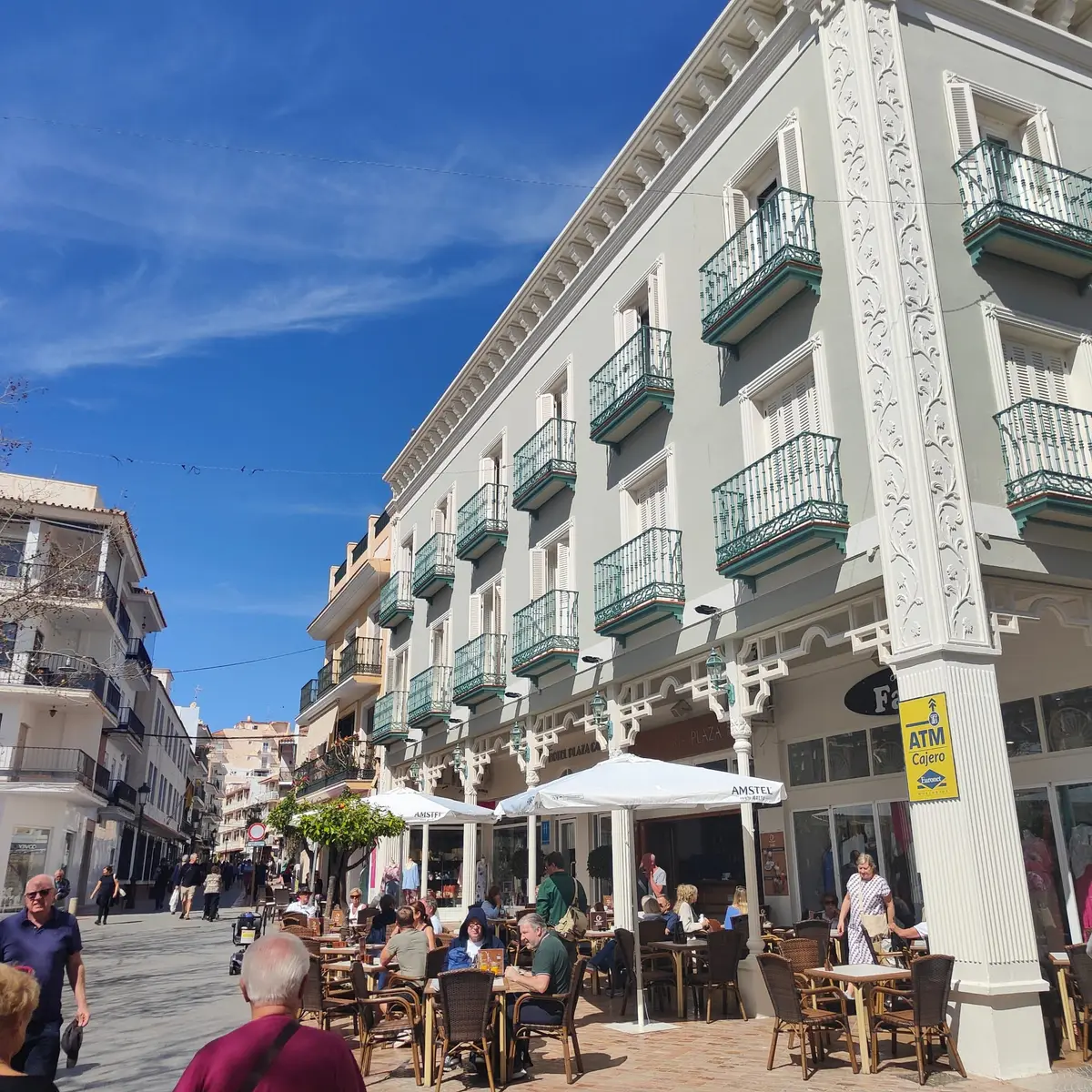 Terrazas en la plaza junto al Balcón de Europa llenándose bajo los balcones decorados