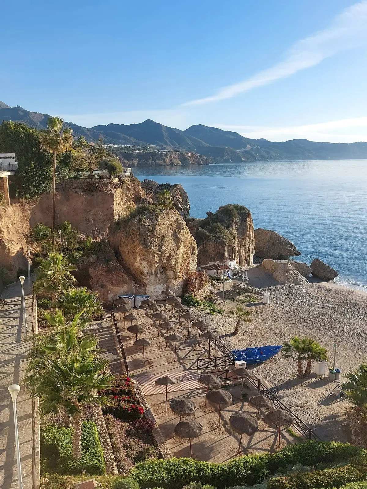 Sombrillas plegadas en una playa vacía bajo los acantilados en invierno